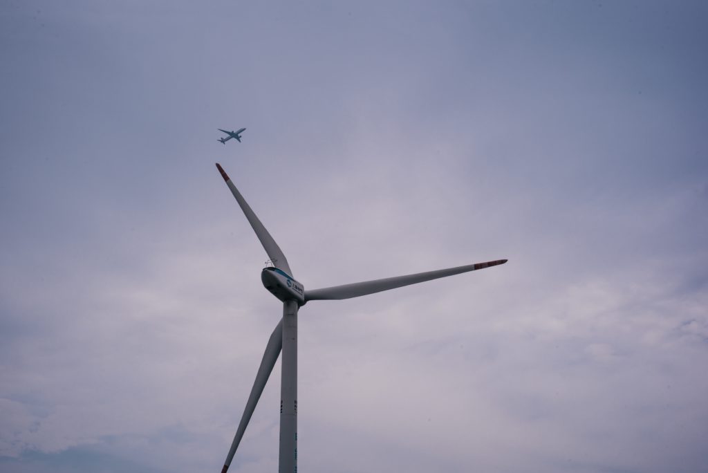 Flugzeug über Windenergieanlage - Durch zunehmende Bauhöhen von Windenergieanlagen kommt es zu immer mehr Konflikten mit der Luftfahrt